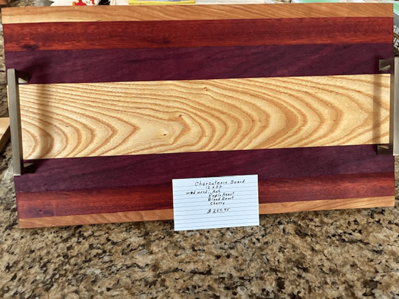 A wooden cutting board with contrasting wood grains and a label.
