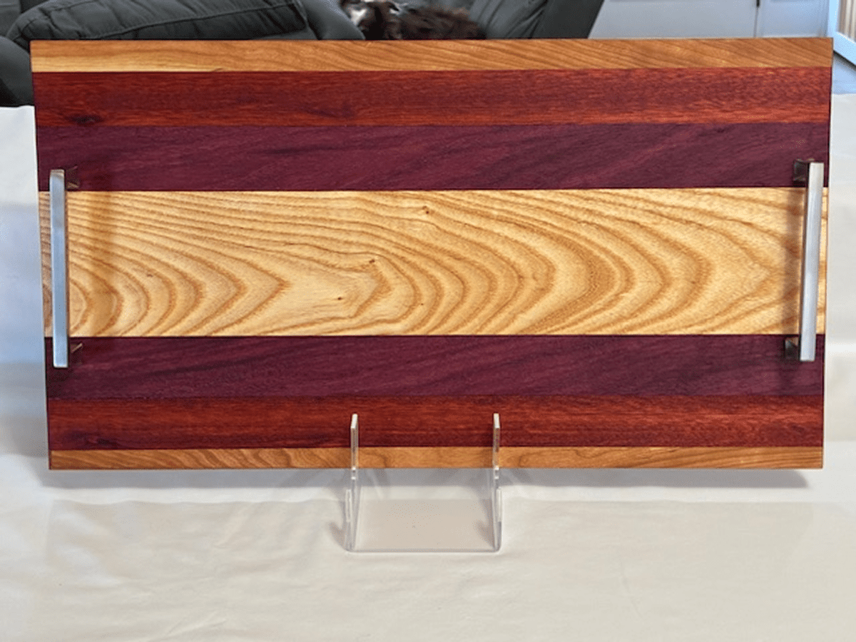 Wooden cutting board with contrasting light and dark wood sections.