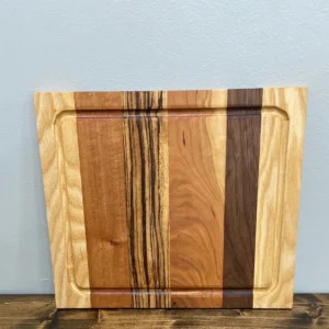 Striped wooden cutting board leaning against wall