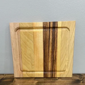 Striped wooden cutting board leaning against gray wall