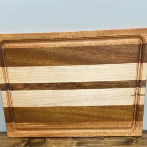 Striped wooden cutting board leaning against blue wall