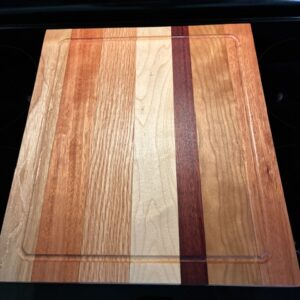 Striped wooden cutting board on stovetop